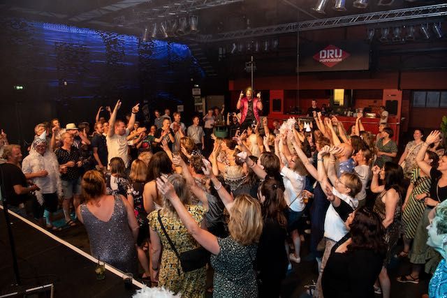Bezoekers vieren feest en genieten van muziek en ontmoetingen tijdens het 25-jarig jubileum van Waterschap Rijn en IJssel, professioneel georganiseerd door Plan X Events.