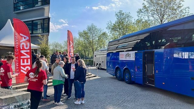 Bezoekers stappen uit de Rensa-bussen en worden gastvrij ontvangen bij het distributiecentrum tijdens de grootschalige Open Deurendag voor 1200 medewerkers, familie en vrienden, georganiseerd door Plan X Events.