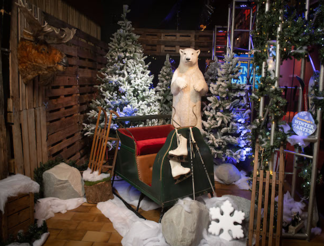 Kerstversiering met ijsbeer, slee en besneeuwde bomen.