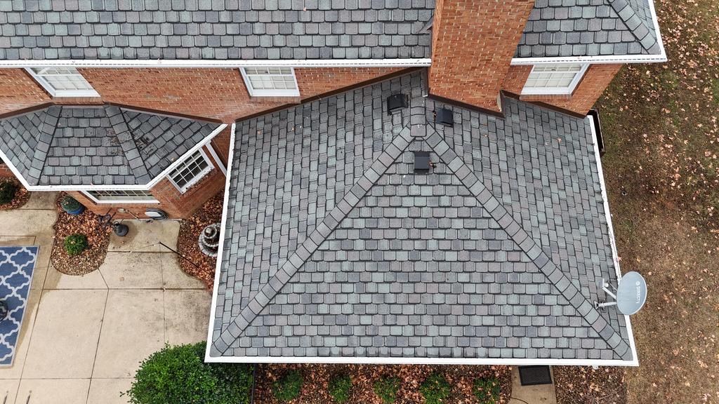 A house with a gray roof and a white garage door
