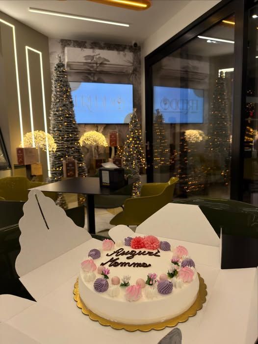 Bicchiere di sorbetto rosso con cucchiaio su un piccolo piattino decorato.