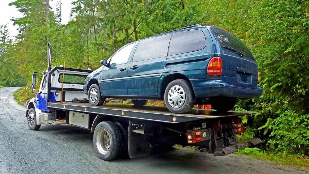 A Blue Van is Sitting on Top of a Tow Truck — Murwillumbah Motor Wreckers in South Murwillumbah, NSW