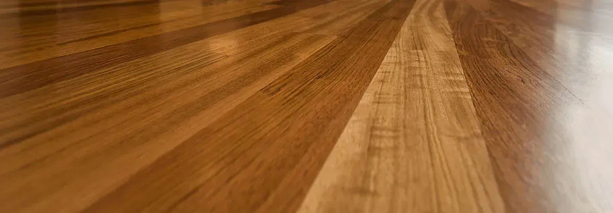 Beige sofa, gray rug with slippers, and light wood flooring.