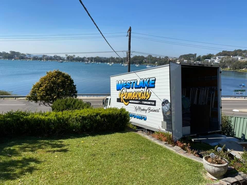 Moving Truck by West Lake Removals Parked on A Grassy Area, with A Lake in The Background — Westlake Removals in Morisset, NSW