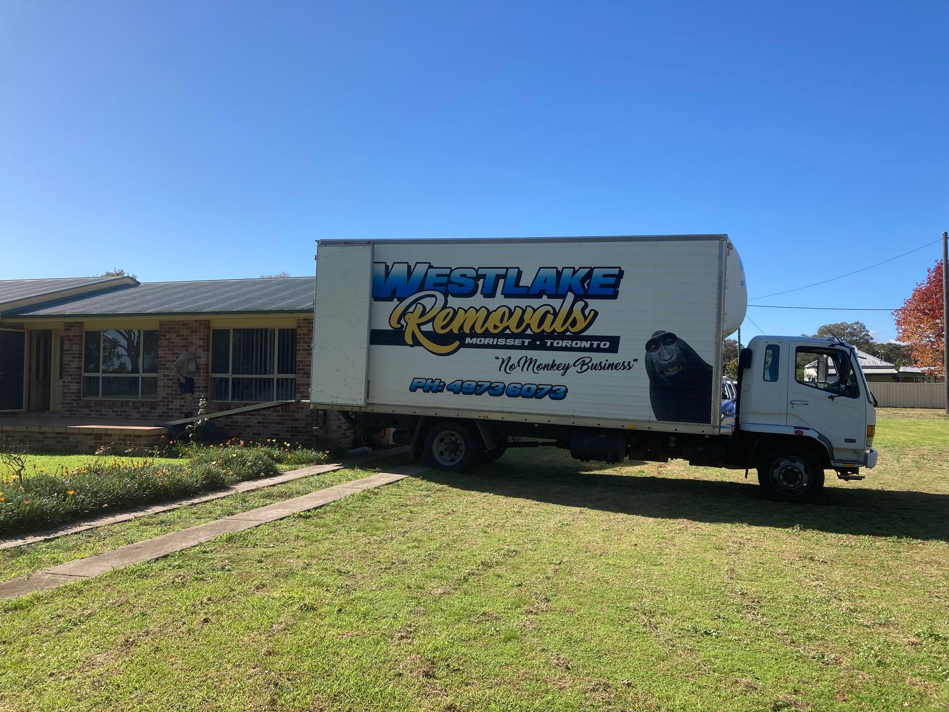 Moving truck from Westlake Removals parked in front of a house on a sunny day.