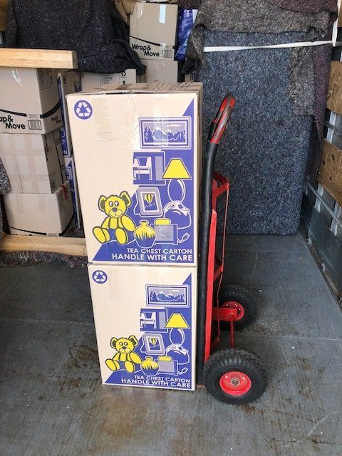 Two Moving Boxes Stacked on A Red Hand Truck in A Truck's Cargo Area — Westlake Removals in Cooranbong, NSW