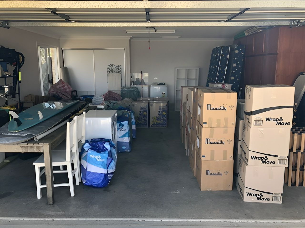 A Cluttered Garage with Boxes, Furniture, and Storage Items — Westlake Removals in Morisset, NSW