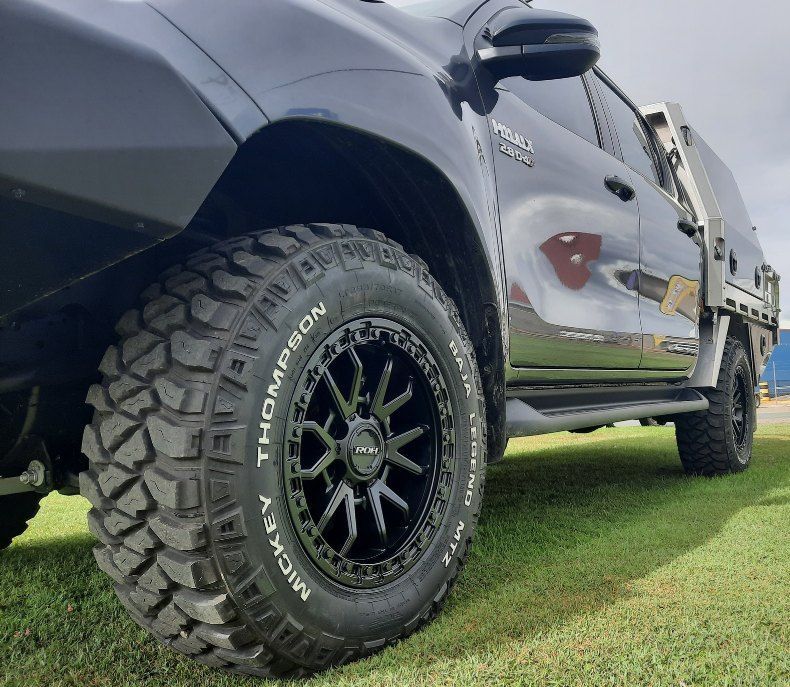 A Black Truck With Michelin Tires Is Parked In A Grassy Field — Clarence Valley Tyre Centre in South Grafton, NSW
