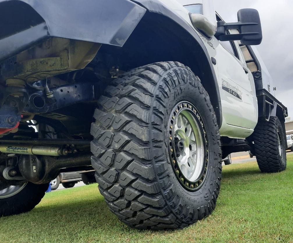 A Truck With A Large Tire Is Parked On The Grass — Clarence Valley Tyre Centre in South Grafton, NSW