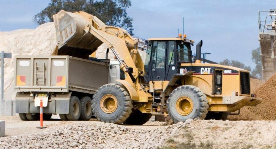 A Cat Bulldozer Is Loading Dirt Into A Dump Truck — Clarence Valley Tyre Centre in South Grafton, NSW