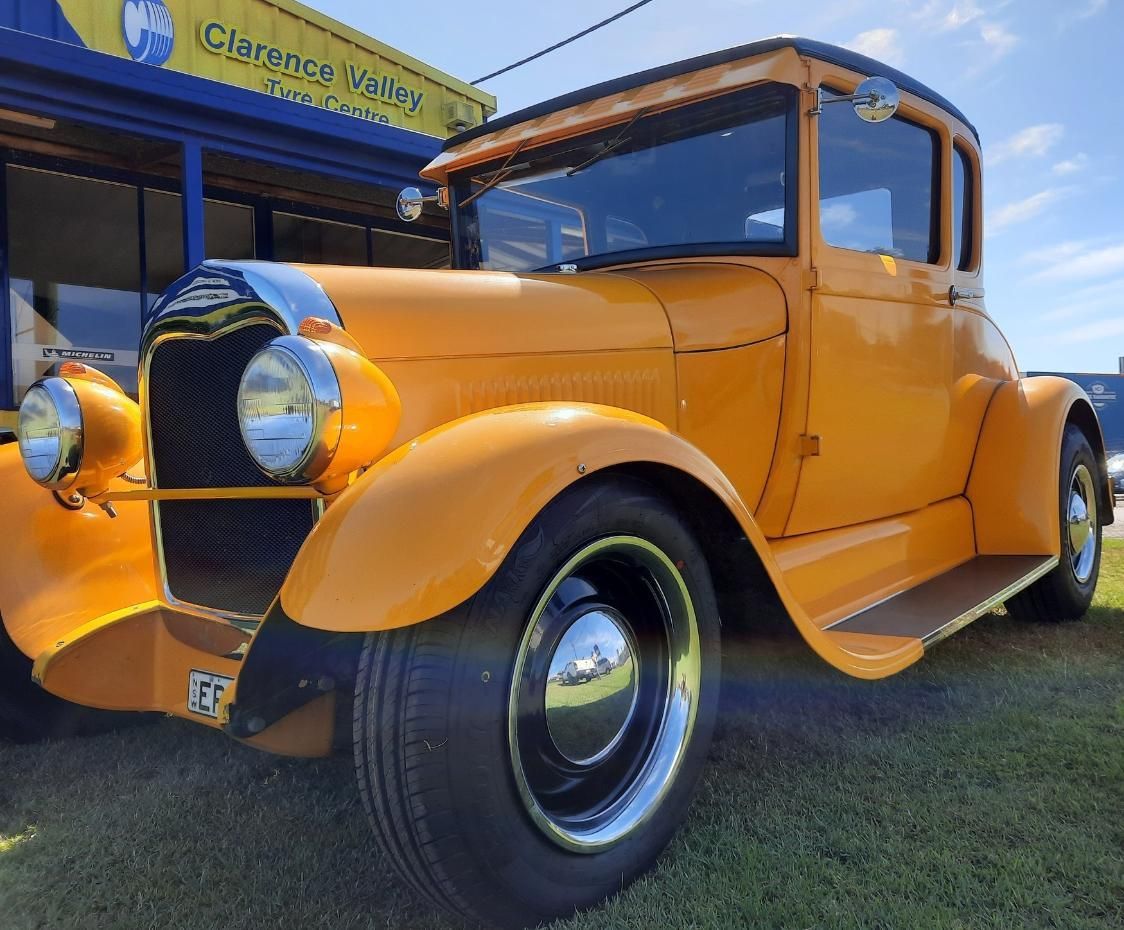 A Yellow Car Is Parked In Front Of A Building That Says Clarence Valley — Clarence Valley Tyre Centre in South Grafton, NSW