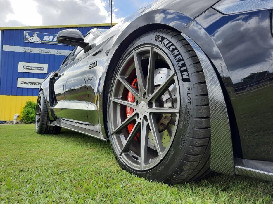 A Black Car With A Michelin Tire On It Is Parked In A Grassy Field — Clarence Valley Tyre Centre in South Grafton, NSW