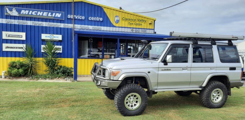 A Silver SUV Is Parked In Front Of A Blue And Yellow Building — Clarence Valley Tyre Centre in South Grafton, NSW