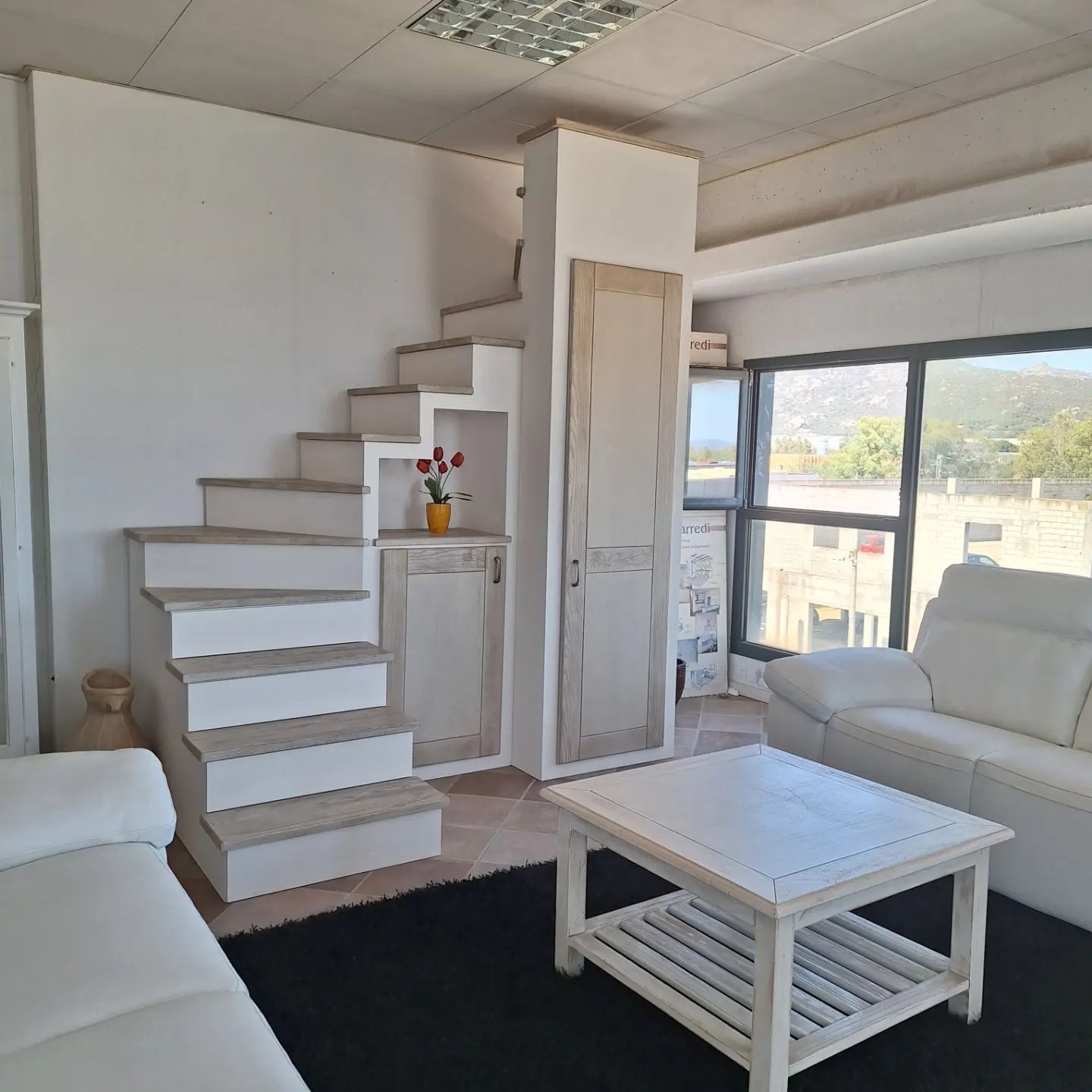 Una donna sorride mentre guarda fuori dalla finestra.