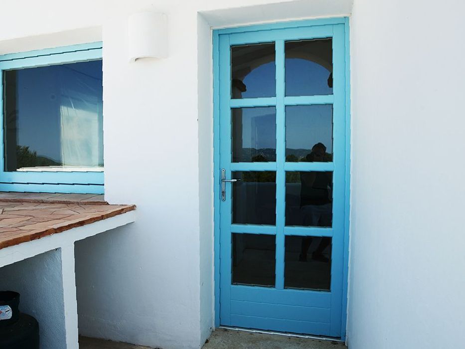 Un soggiorno con tende, una sedia e una pianta in vaso.