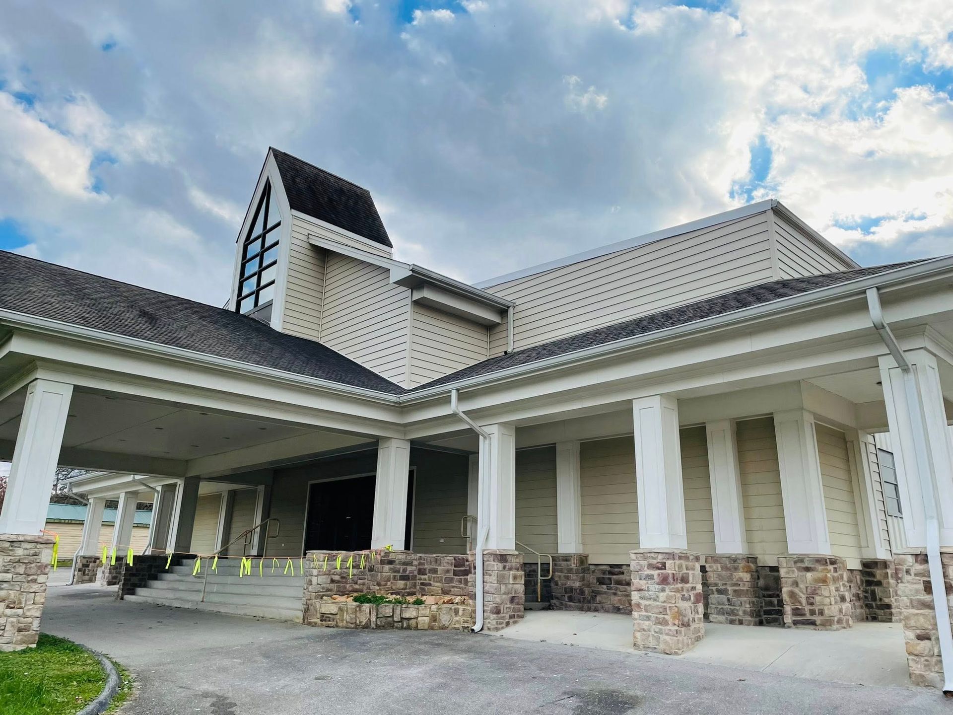 A large white building with a black roof and a porch.
