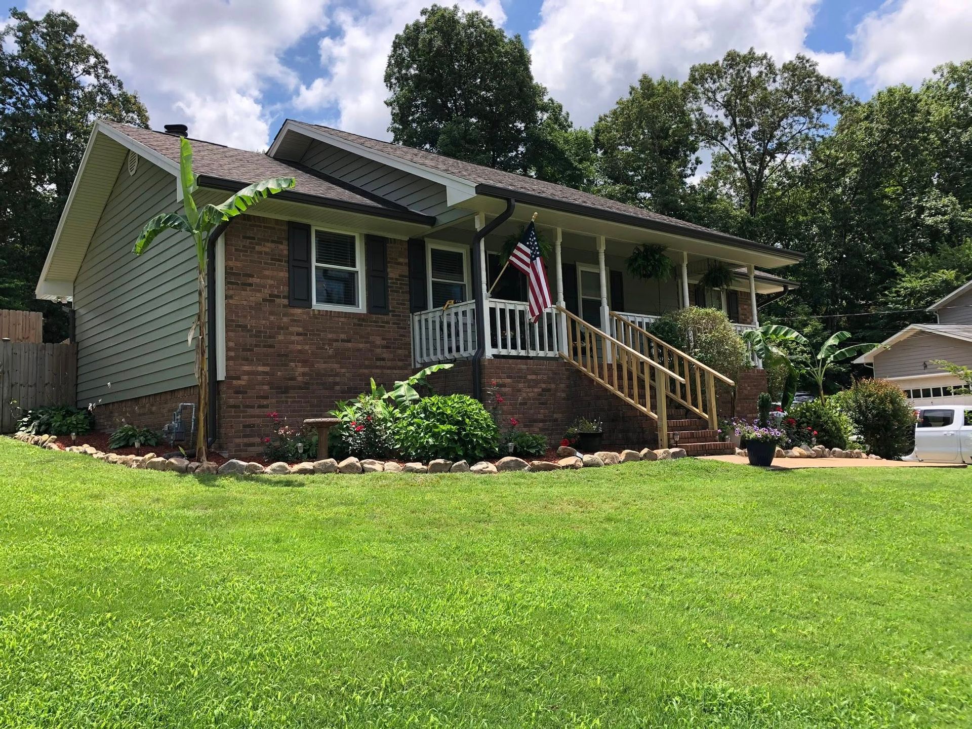 A brick house with a large lawn in front of it.