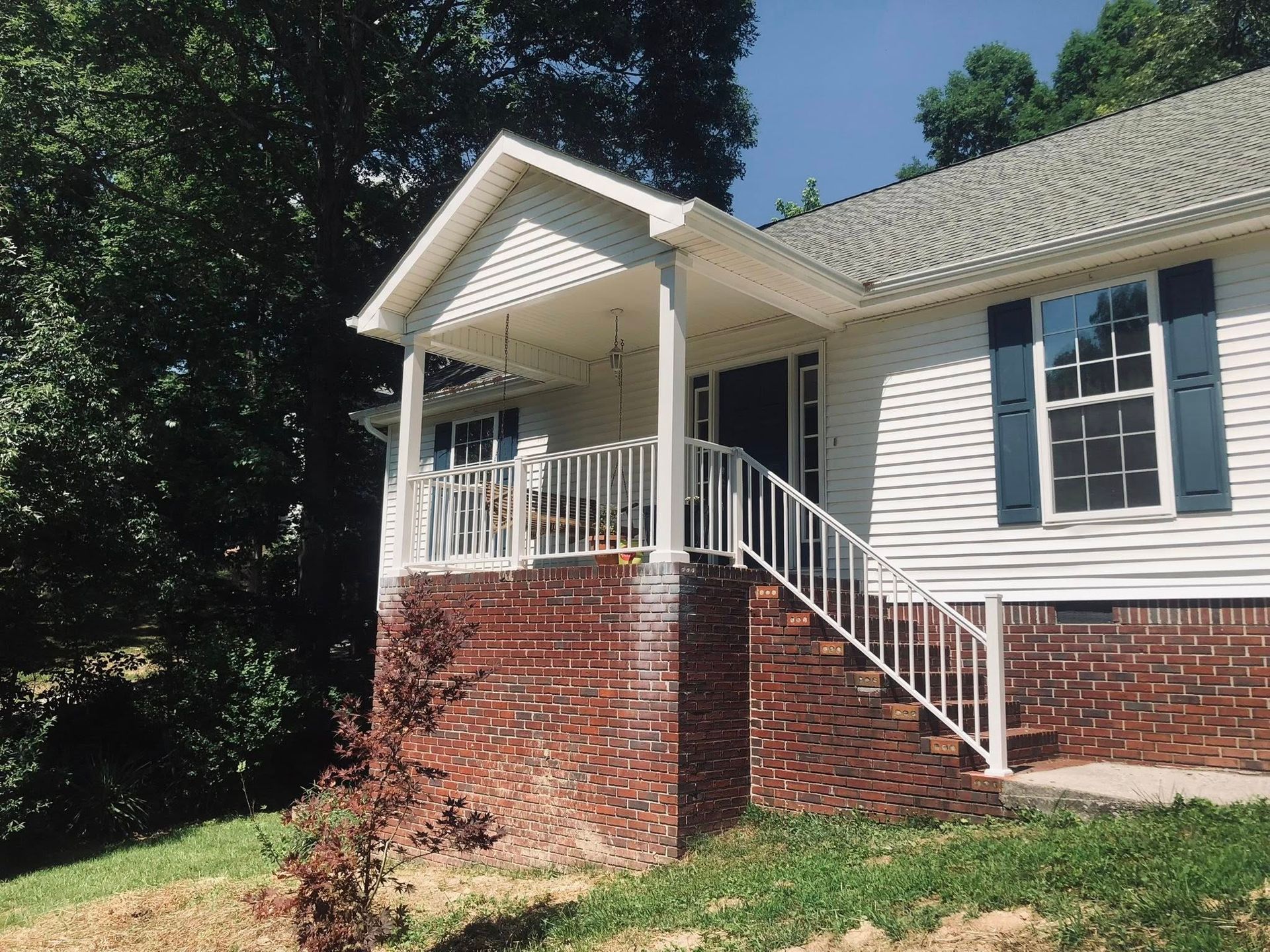 A white house with blue shutters and a porch