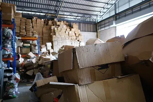 A warehouse filled with lots of cardboard boxes and shelves.