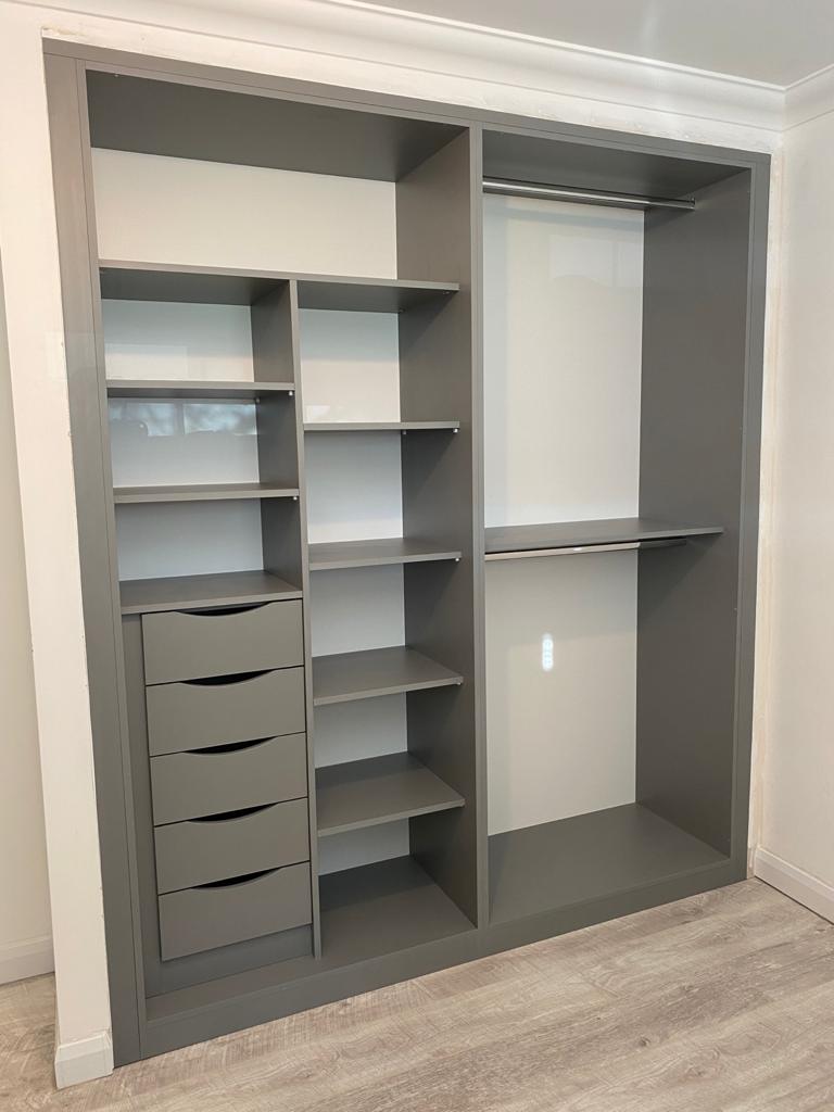 A closet with lots of shelves and drawers in a room.