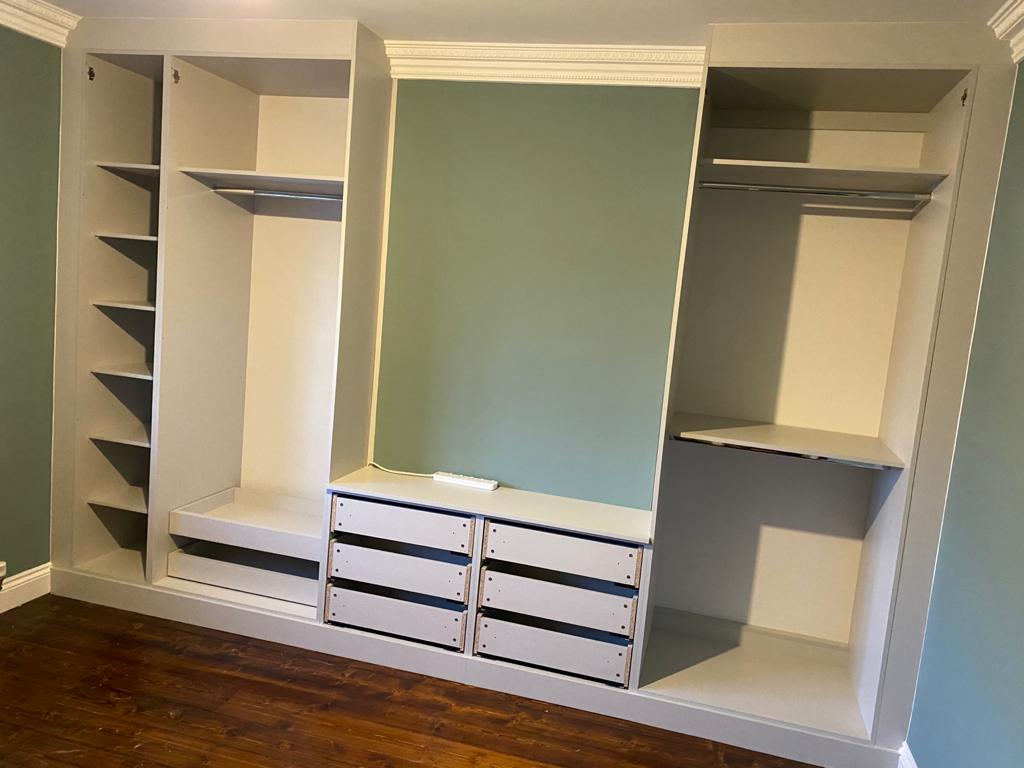 A closet with lots of shelves and drawers in a room.