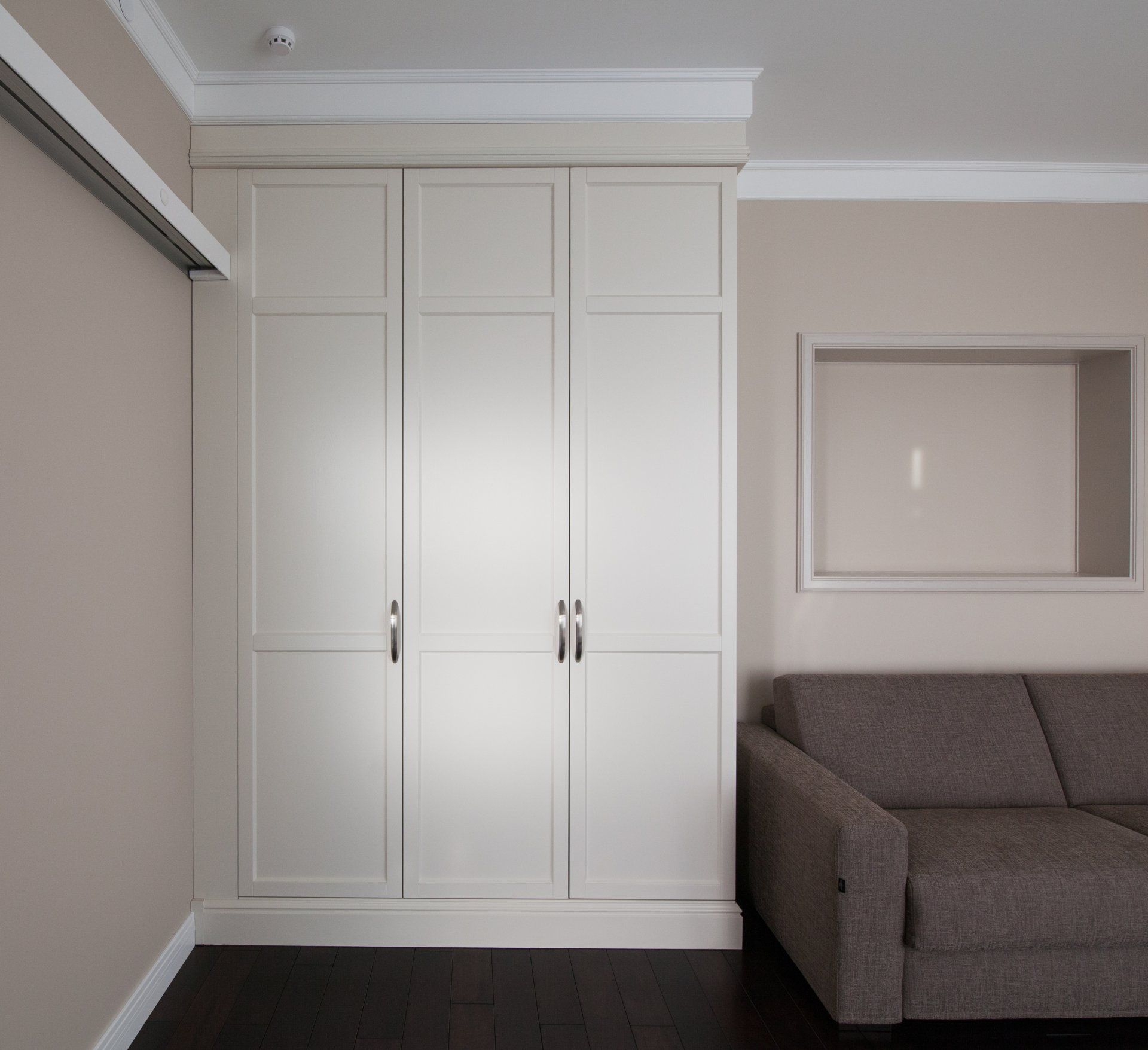 A living room with a couch and white cabinets