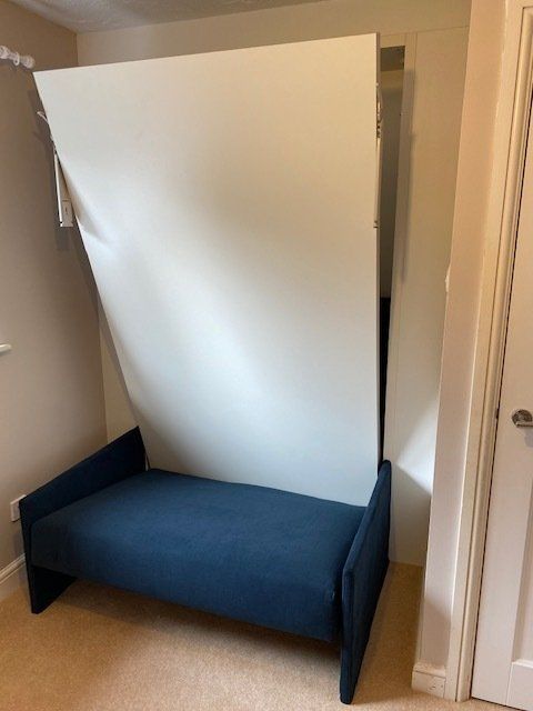 A blue couch with a white wall behind it