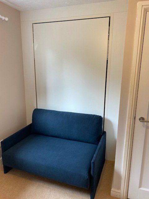 A blue couch with a white wall behind it