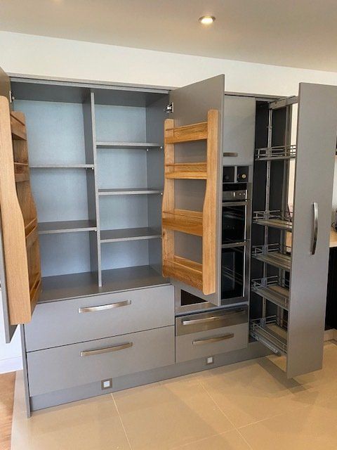 A kitchen with lots of shelves and drawers and a pantry.
