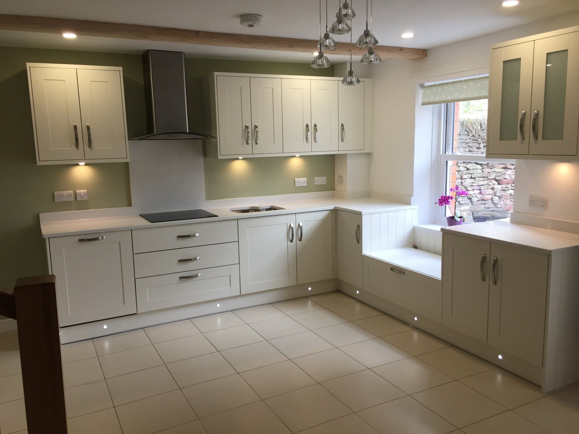 A kitchen with white cabinets and a window