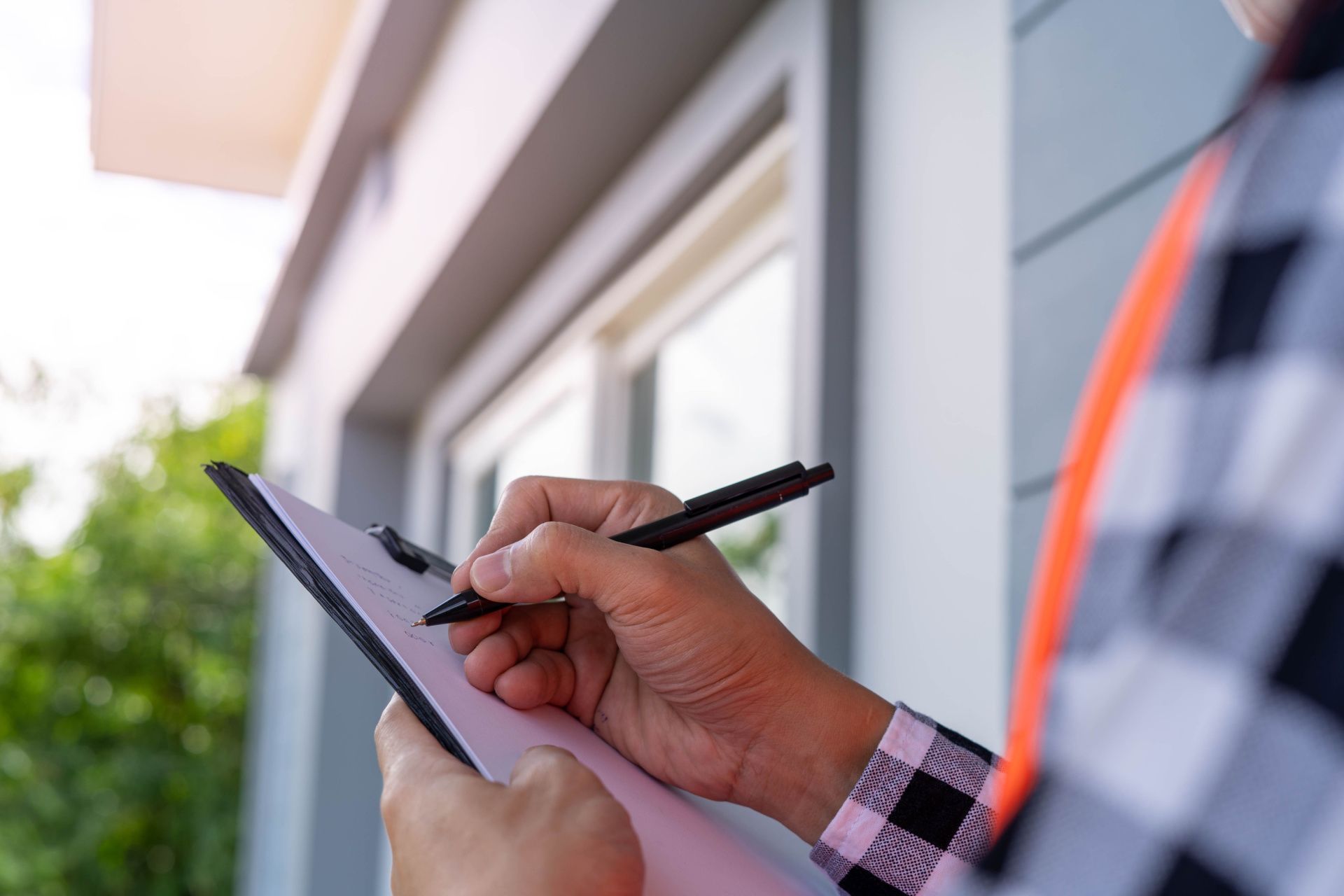a man is writing on a clipboard with a pen .