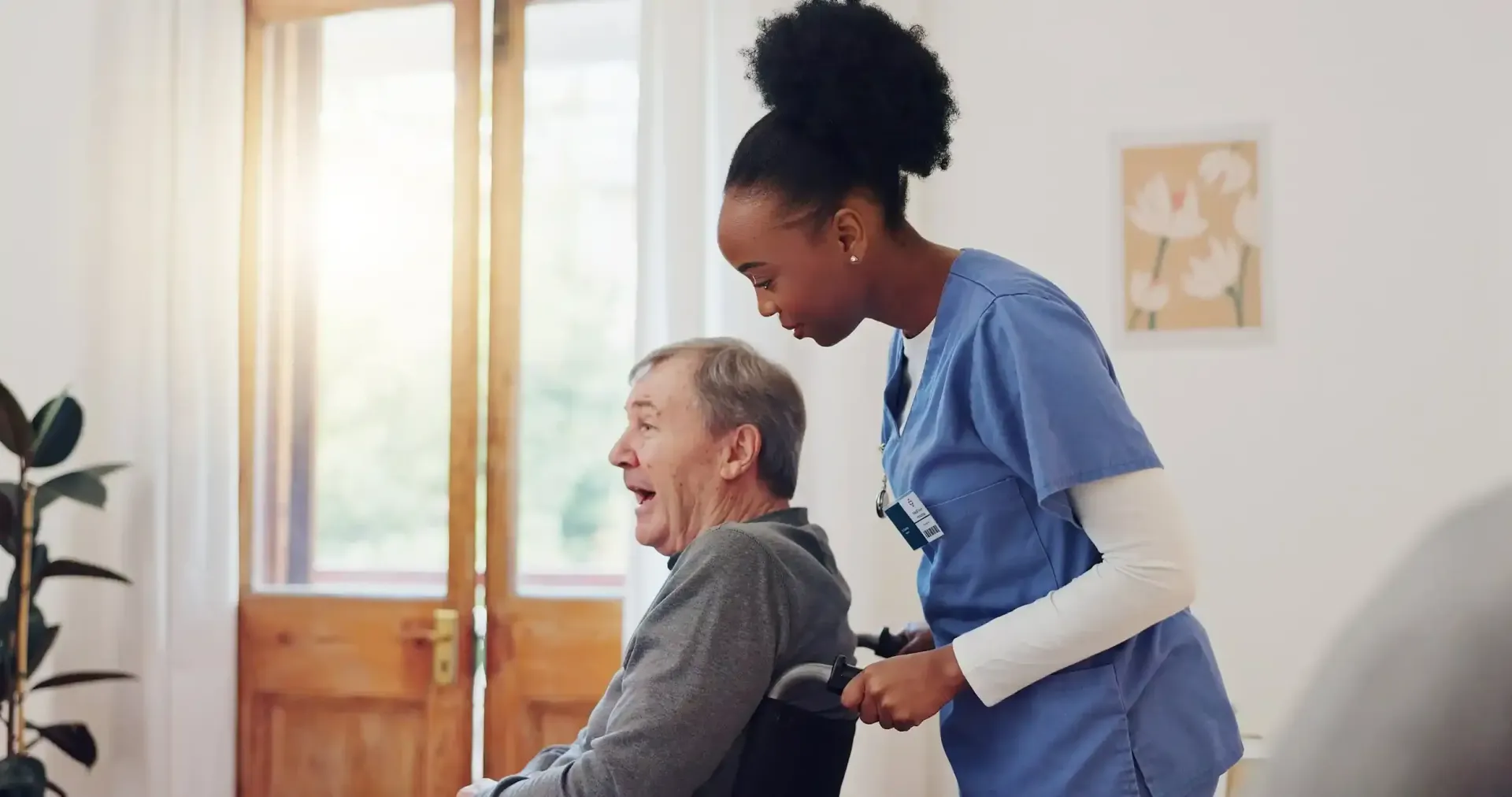 A nurse is helping an elderly man in a wheelchair.