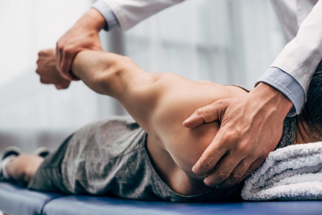 picture of medical provider stretching a patient’s arm during treatment