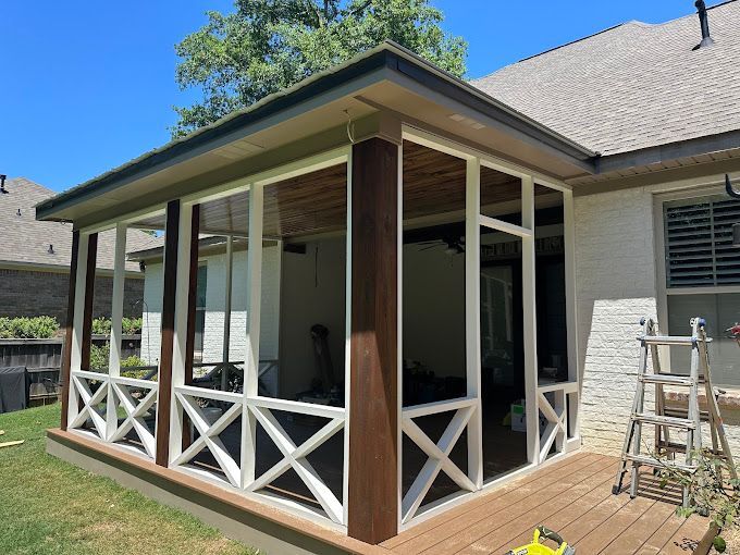 A screened in porch is being built on the side of a house.