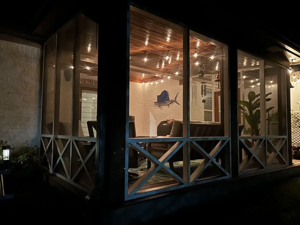 A screened in porch is lit up at night