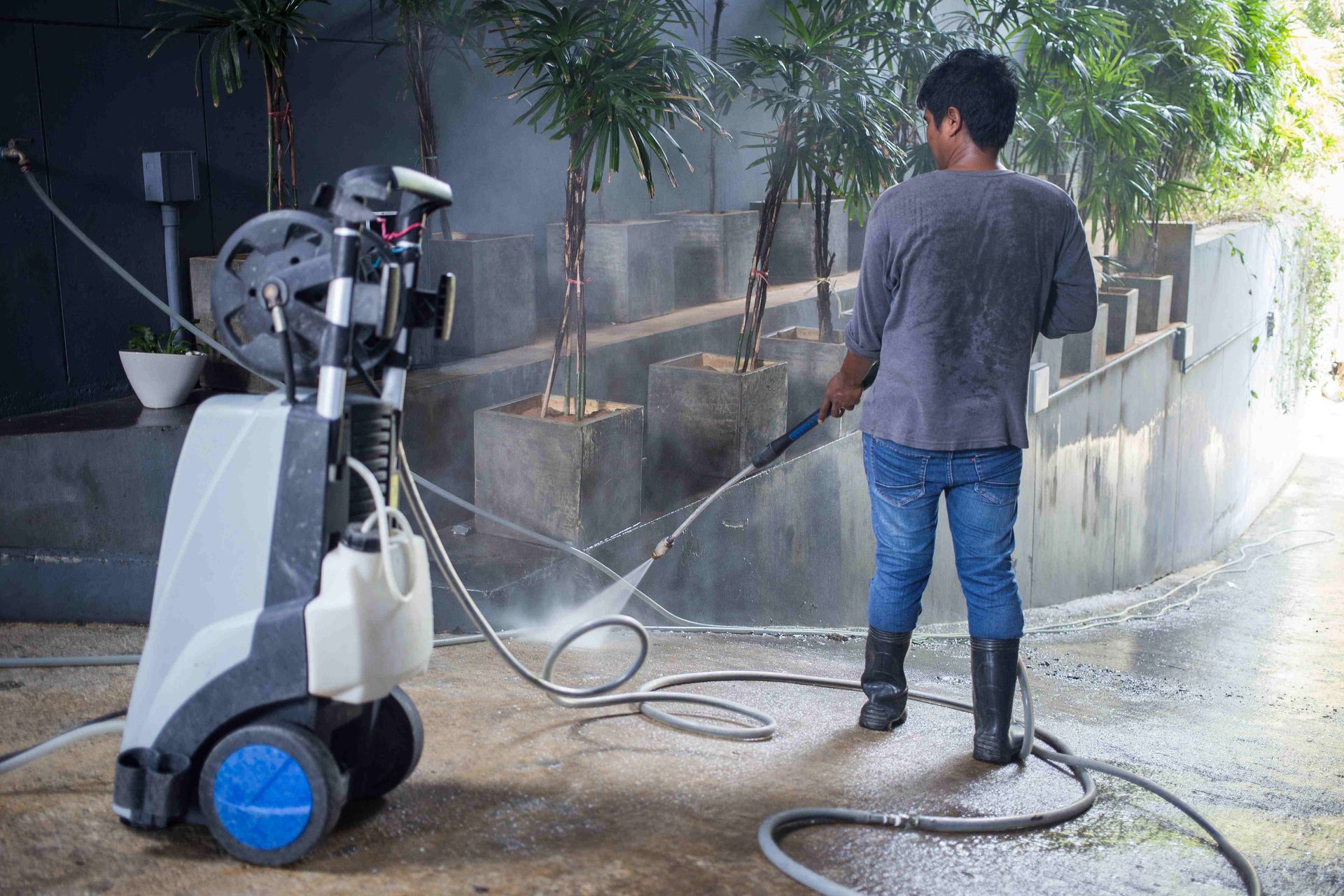 a man is using a high pressure washer to clean a sidewalk