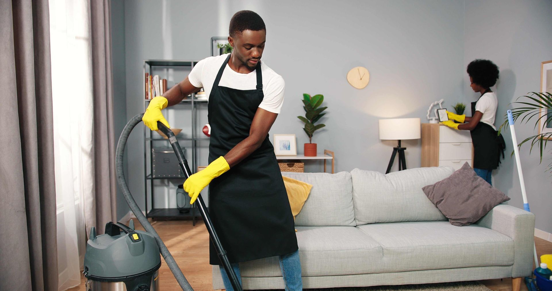 a man is cleaning a living room with a vacuum cleaner