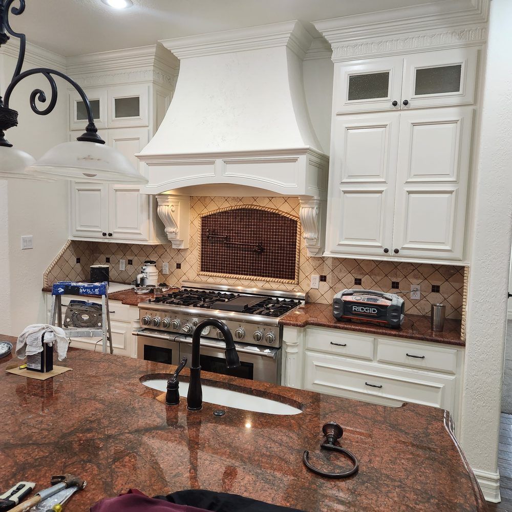 Kitchen with white cabinets, granite countertops, and a stainless steel stove.