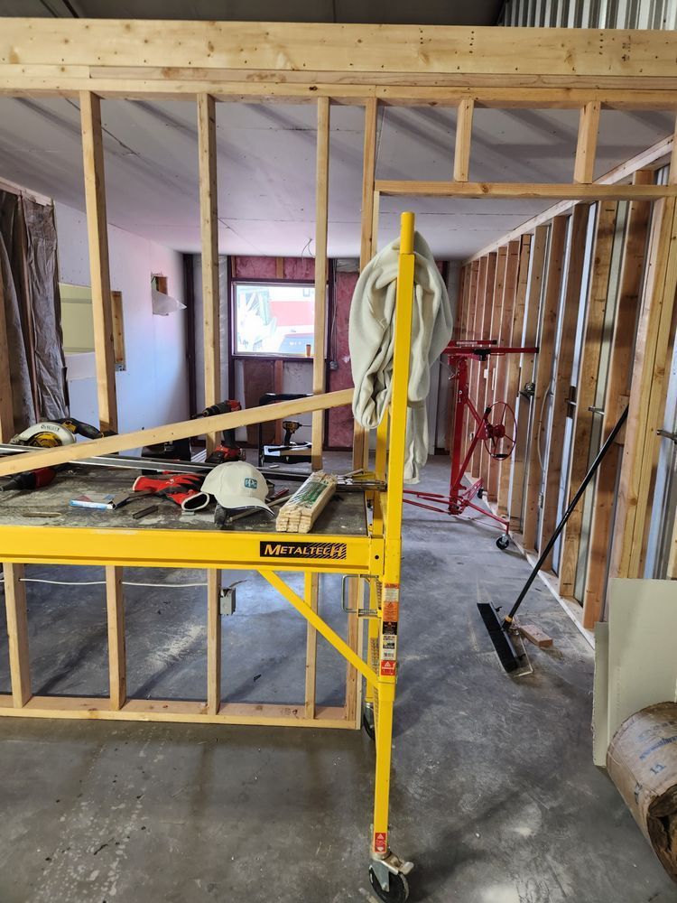 Interior framing of a room under construction, with scaffolding and tools.