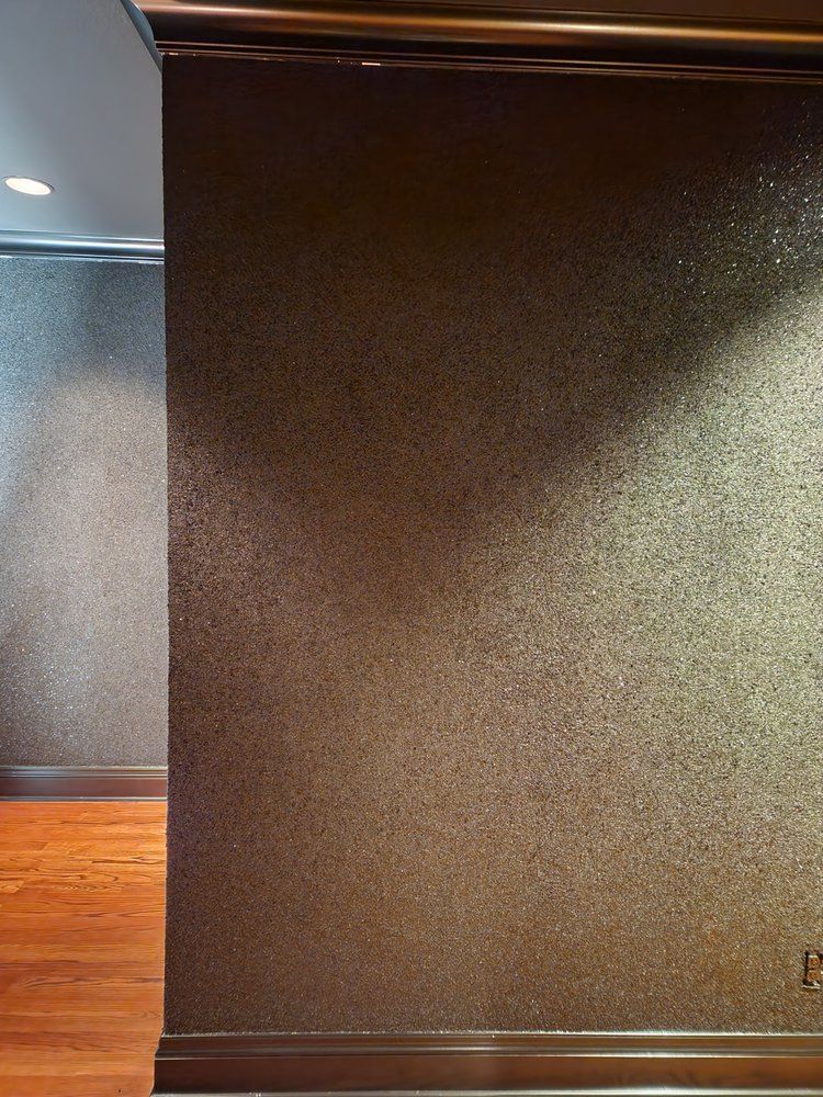 Brown textured walls with wooden trim, casting a shadow.