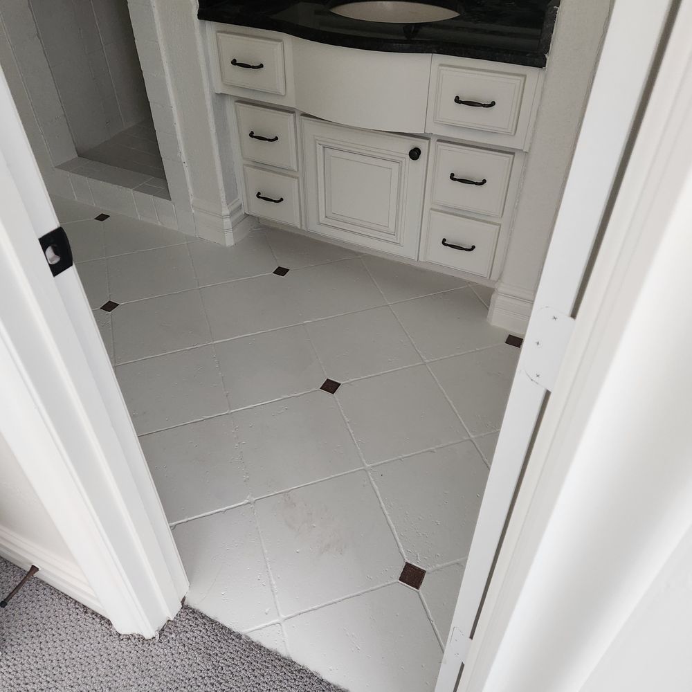 Bathroom with white tiles, dark accents, white vanity, and black hardware.