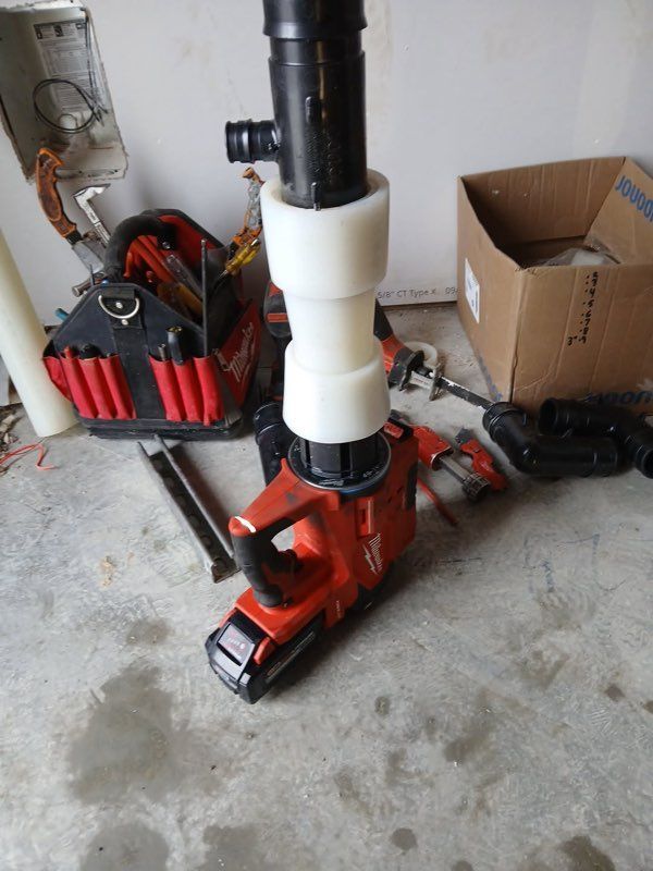 Plumber unclogging bathroom sewage by turning steel cable.