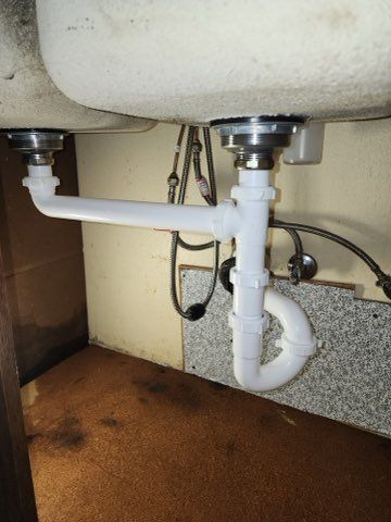 A plumber explaining to a client the problem with her kitchen sink.