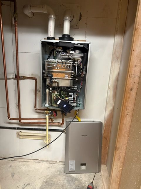 Open furnace with exposed components beside a gray water heater in a utility room