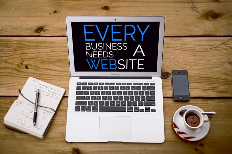 laptop with why every business needs a website on the screen