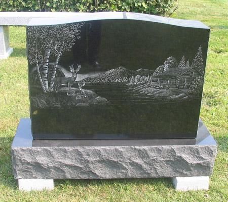 A black gravestone with a deer and trees on it
