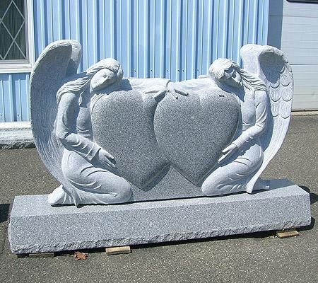 A statue of two angels holding a large heart