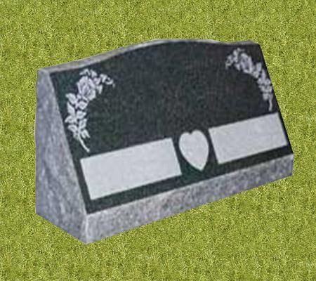 A gravestone with a heart and roses on it is sitting on top of a lush green field.