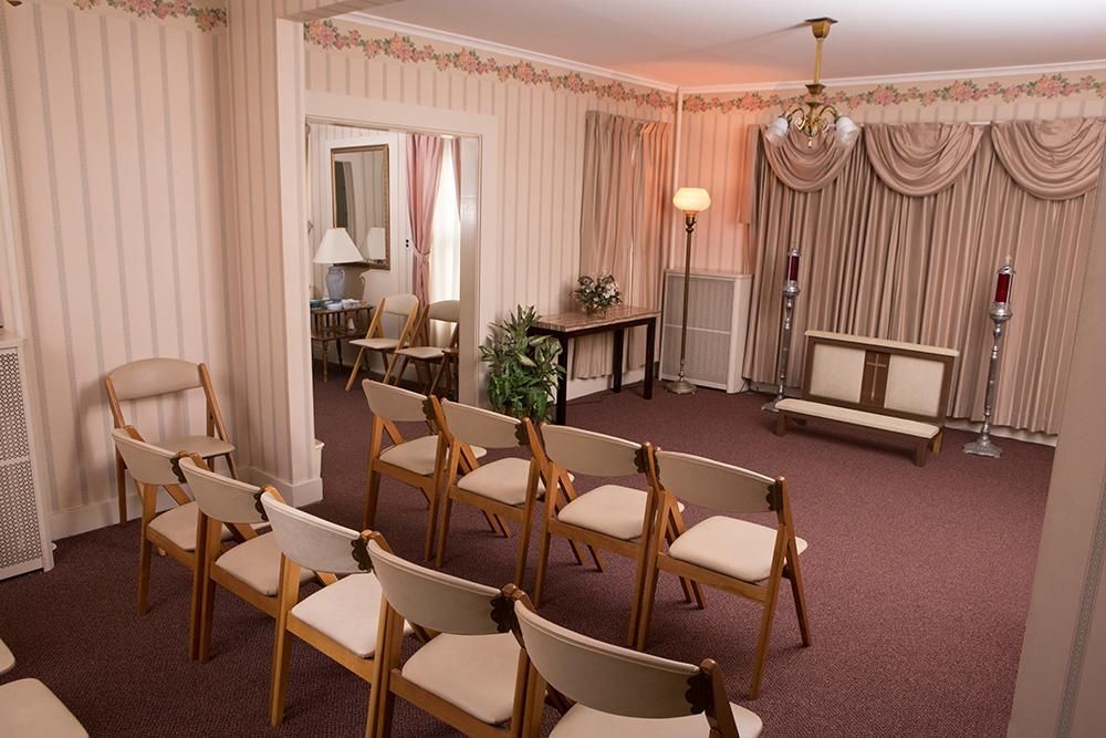 A row of folding chairs are lined up in a room.