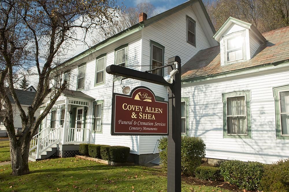 A large white house with a sign in front of it